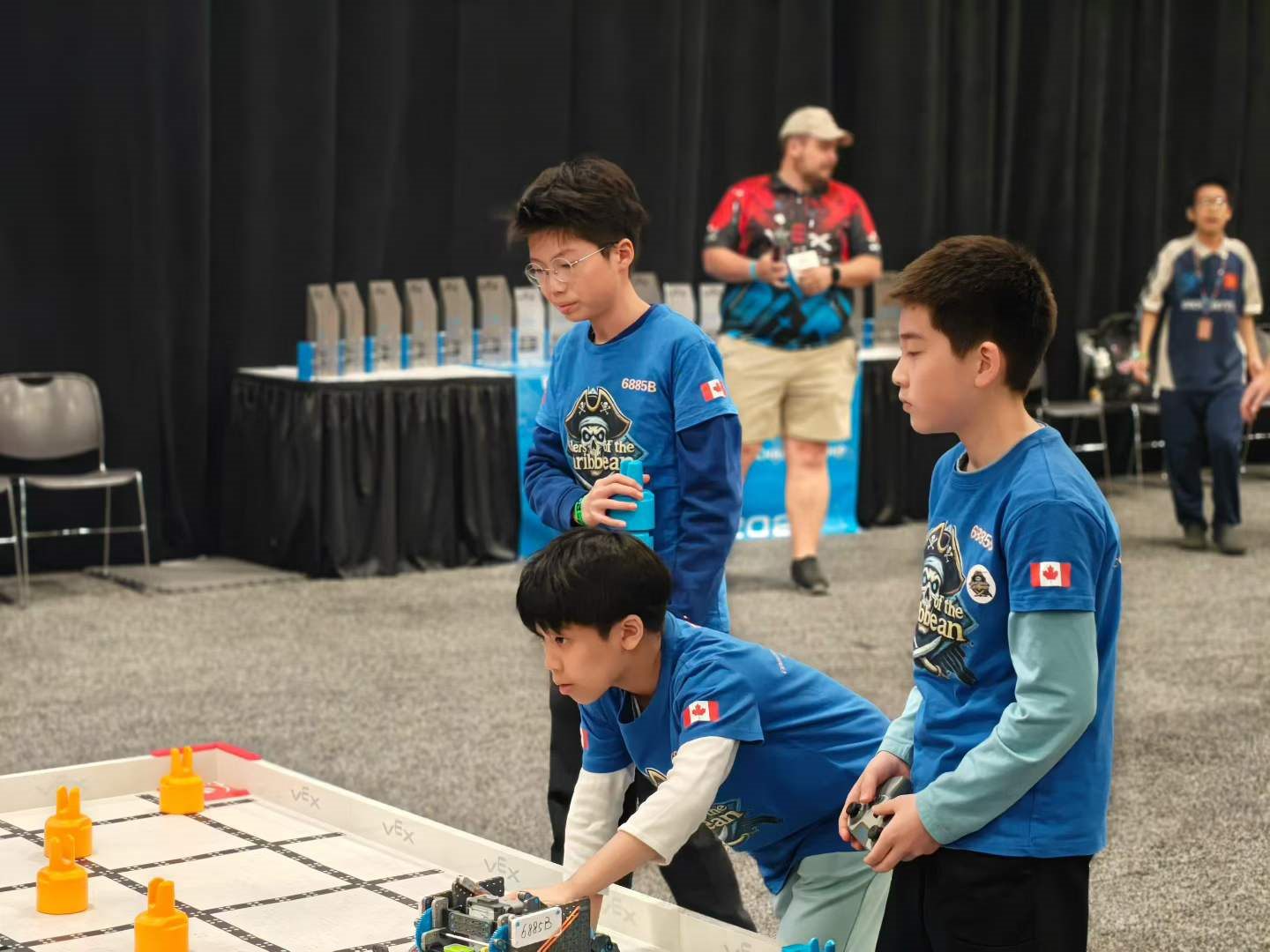 Two RoboPlanet students driving their VEX IQ robot on the competition field