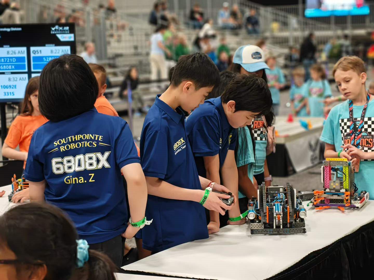 Students gathered around a table adjusting their VEX IQ robot between matches
