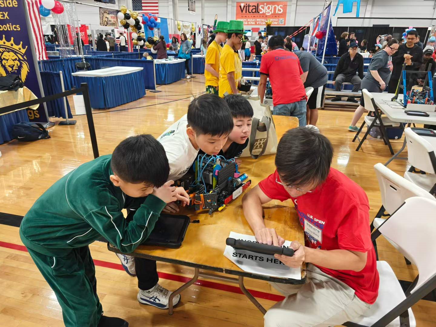 Team members working together on their robot in the pit area at the US Open