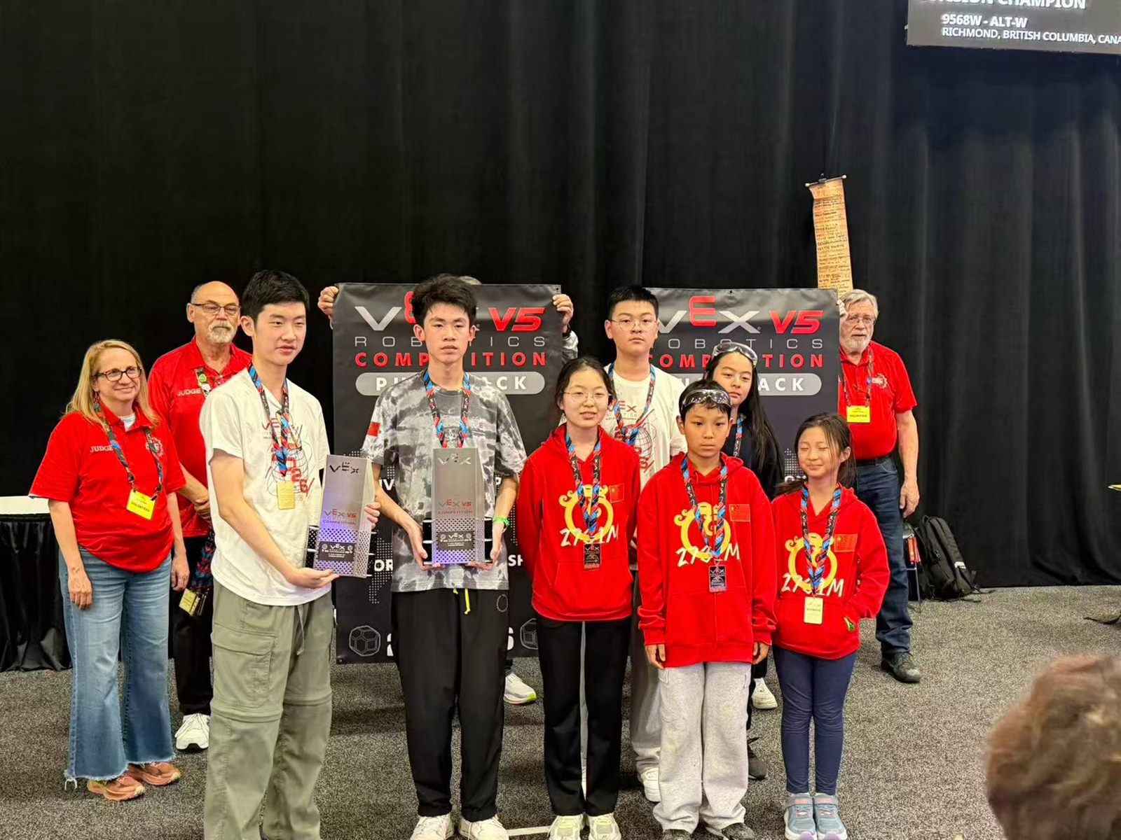 RoboPlanet team and coaches with their division banner and trophy